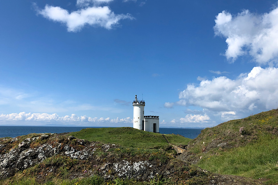 Weißer Leuchtturm an der Küste Schottlands