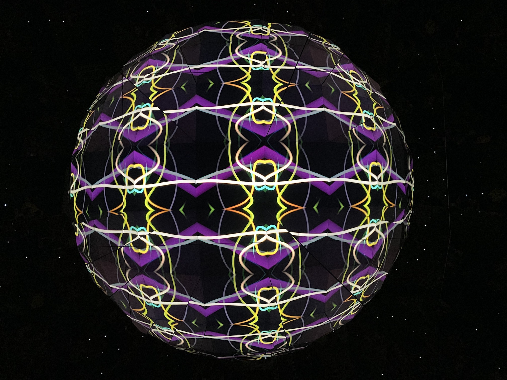 3 dimensionale Kugel in violett und grün vor schwarzem Hintergrund